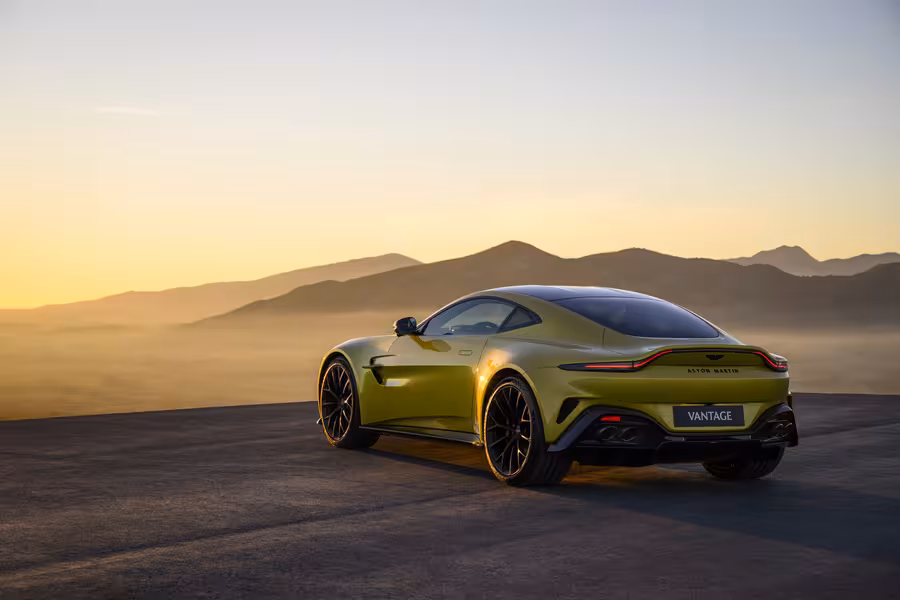Zadní tříčtvrteční pohled na žlutý současný Aston Martin Vantage
