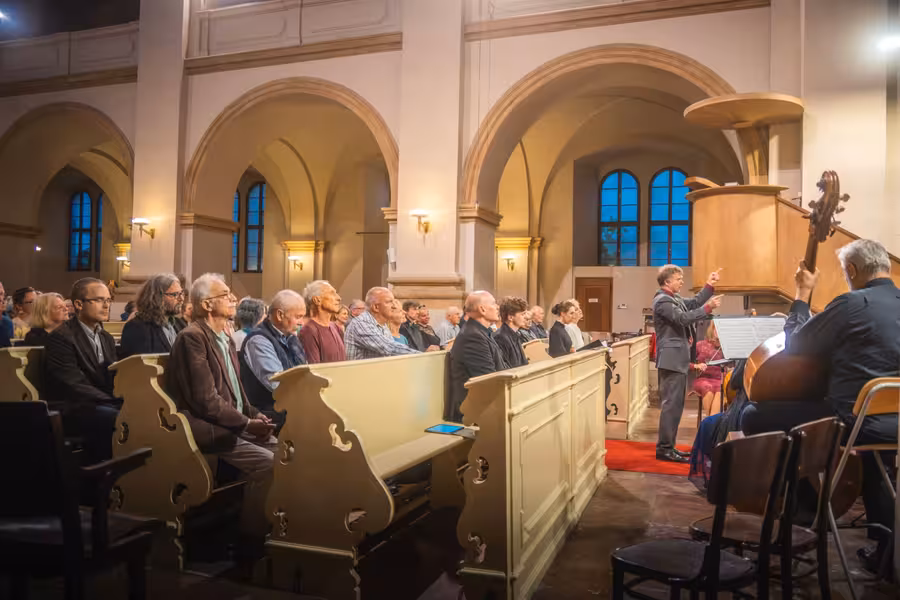 Dirigent a hudebníci Musica Florea před publikem v kostele U Salvátora