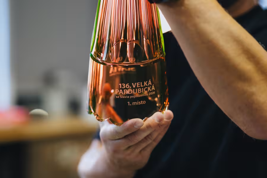 Detail rubínově červeného skla a nápisu 136. Velká pardubická, 1. místo na trofeji