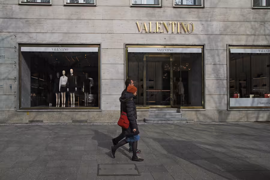 Kamenná fasáda boutique Valentino na berlínském Kurfürstendammu se zlatým nápisem a třemi výlohami