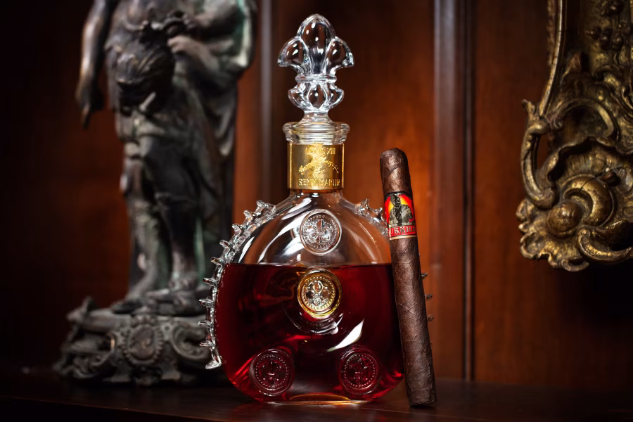 Doutník Gurkha His Majesty’s Reserve stojí vedle skleněné karafy koňaku v tmavém dřevěném interiéru