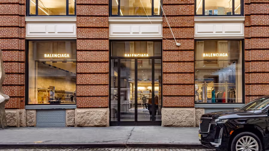 Prosklený butik Balenciaga se třemi svítícími logy zabírá přízemí cihlové budovy na Manhattanu