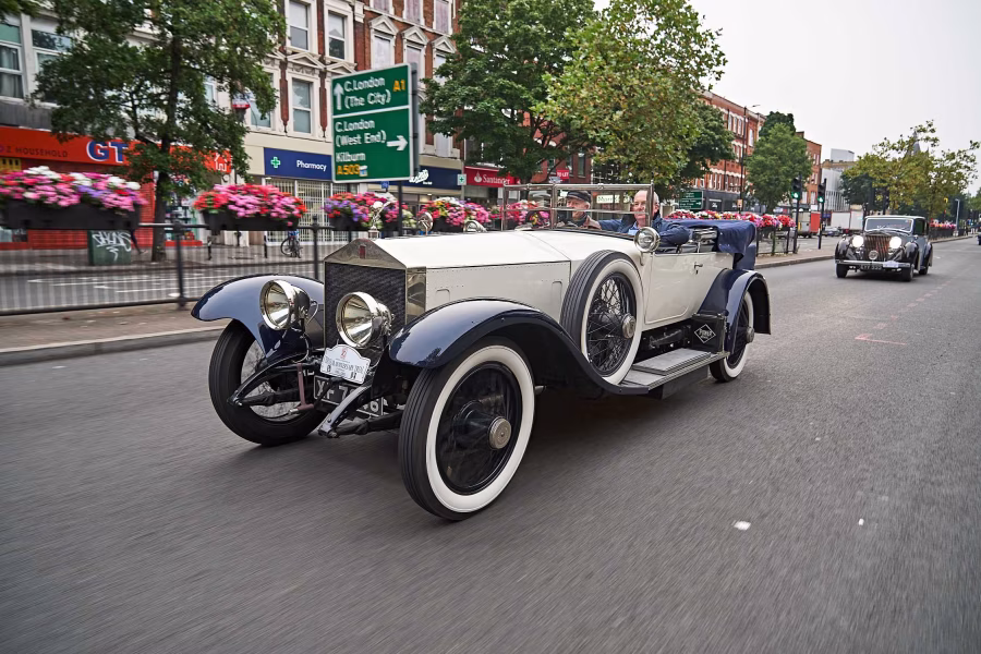 Historický otevřený Rolls-Royce Silver Ghost jede v koloně městskou ulicí