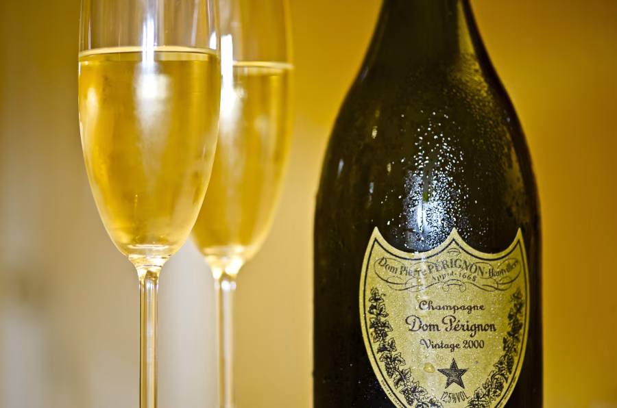 Otevřená lahev Dom Pérignon se dvěma sklenkami šampaňského
