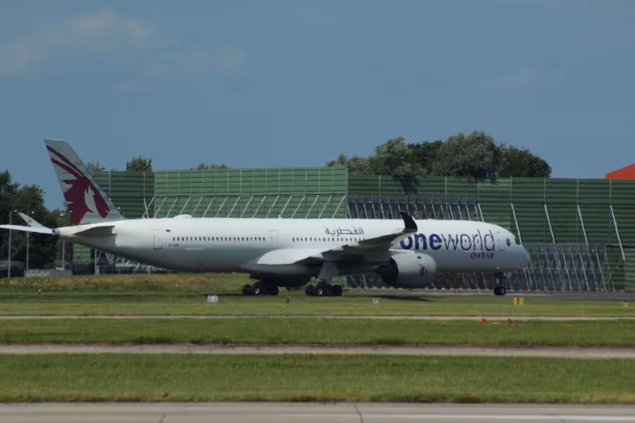 Airbus A350-1000 Qatar Airways s nápisem oneworld pojíždí u letištní dráhy v Manchesteru