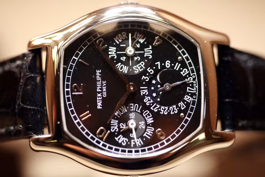 Detail zlatých hodinek Patek Philippe s černým číselníkem, věčným kalendářem a měsíční fází