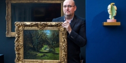 Galerista Tomáš Hejtmánek s obrazem Lesní cesta